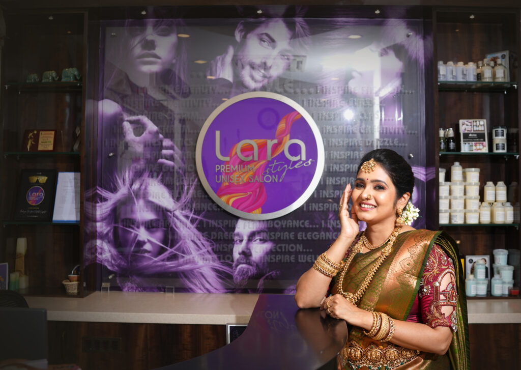 Bride in gold jewelry and vibrant green-red saree, bridal makeup by Lara Styles Unisex Salon Coimbatore